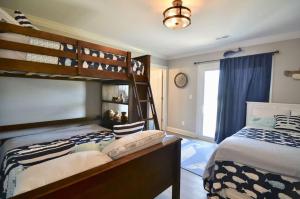 a bedroom with two bunk beds and a window at 5 BR Poolside Paradise Just Steps from the Beach in Ocean Isle Beach