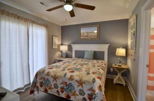 a bedroom with a bed and a ceiling fan at 5 BR Poolside Paradise Just Steps from the Beach in Ocean Isle Beach +20 photos