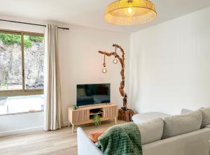 a living room with a couch and a television at Ninho da Ribeira in Ribeira Brava