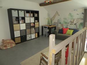 a living room with a couch and a book shelf at Les Lilas in Saint-Clair
