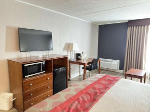 a hotel room with a bed and a flat screen tv at Ramada by Wyndham Vineland Millville Area in Vineland