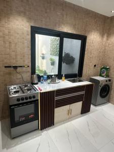 a kitchen with a stove and a sink and a window at Résidence MBK Suite in Ziguinchor
