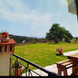 a balcony with a view of a green field at Grace, fifteen minutes drive away from the beach in Kolymvari