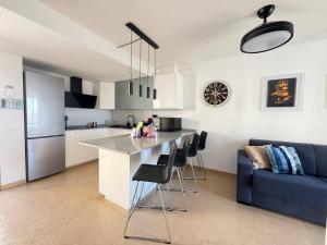 a kitchen and living room with a blue couch at NextGen Casa Pepa I Terrace & Pool Fuerteventura in Costa de Antigua
