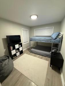 a room with a bunk bed and a television at Uptown Modern Escape 4bd 2ba in Memphis