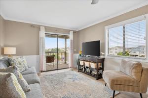 a living room with a couch and a tv at Castle By The Sea Beach Front Condo in Ocean Isle Beach