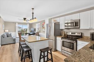 a kitchen with white cabinets and a counter top at Castle By The Sea Beach Front Condo in Ocean Isle Beach
