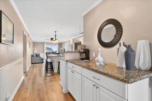 a kitchen with a counter with a mirror on the wall at Castle By The Sea Beach Front Condo in Ocean Isle Beach