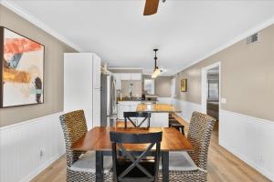 a dining room and kitchen with a table and chairs at Castle By The Sea Beach Front Condo in Ocean Isle Beach +18 photos