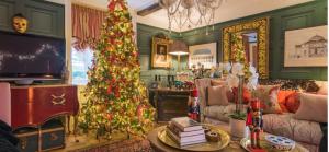 a living room with a christmas tree and a tv at 16th Century Manor House in Richborough