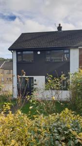 a dog sitting in the window of a house at 15 Kershaw Crescent in Luddenden Foot