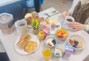 a table topped with plates of breakfast foods at Hôtel Kyriad Epernay en Champagne in Épernay