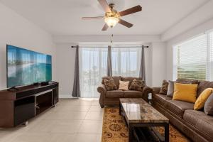 a living room with a couch and a flat screen tv at Beachfront Condo with Spacious Balcony in Daytona Beach