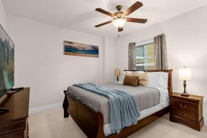 a bedroom with a bed and a ceiling fan at Beachfront Condo with Spacious Balcony in Daytona Beach