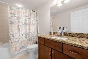 a bathroom with a toilet and a shower curtain at Beachfront Condo with Spacious Balcony in Daytona Beach +14 photos