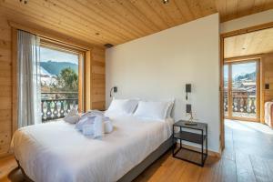 a bedroom with a large bed and a large window at Appartement Gondola & Spa - MultiPass in Les Gets