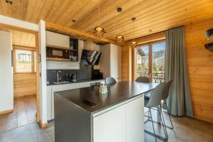 a kitchen with a large island in a cabin at Appartement Gondola & Spa - MultiPass in Les Gets