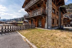 a house with a balcony on the side of it at Appartement Gondola & Spa - MultiPass in Les Gets