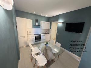 a kitchen with a glass table and white chairs at The Smerald in Alghero