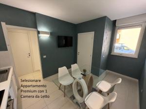 a dining room with a table and white chairs at The Smerald in Alghero