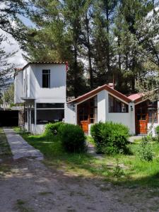 a white house with trees in the background at Casona Urinsaya Qolca in Chivay +15 photos