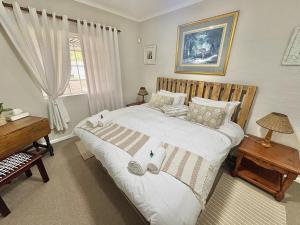a bedroom with a bed and a desk and a window at FIVE on Fraser in Howick