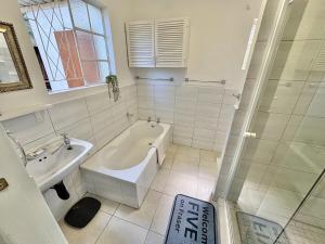 a bathroom with a bath tub and a sink at FIVE on Fraser in Howick +20 photos