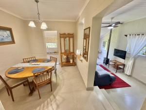 a dining room and living room with a table and chairs at FIVE on Fraser in Howick