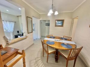 a dining room with a wooden table and chairs at FIVE on Fraser in Howick