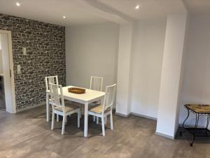 a white table and chairs in a room with a brick wall at Salinenappartement in Bad Kreuznach