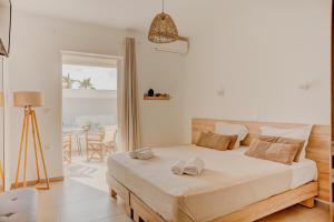 a bedroom with a bed with two towels on it at Indigo Seaside Experience in Adelianos Kampos