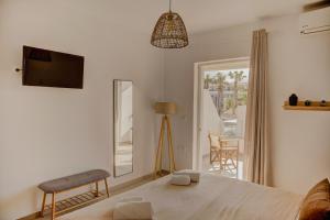 a bedroom with a bed and a mirror and a chair at Indigo Seaside Experience in Adelianos Kampos