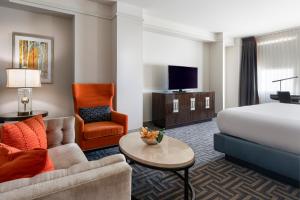 a hotel room with a bed and a couch and a chair at Colcord Hotel Oklahoma City, Curio Collection by Hilton in Oklahoma City
