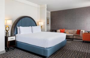 a hotel room with a large bed and a couch at Colcord Hotel Oklahoma City, Curio Collection by Hilton in Oklahoma City +74 photos