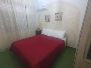 a red and white bed in a small room at Casa Luisa in Sarroch +6 photos