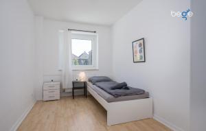 a white bedroom with a bed and a window at BEGE APARTMENTS ProStay in Lüdenscheid +5 photos