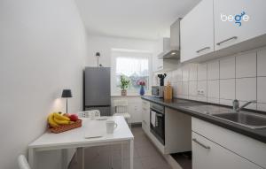 a white kitchen with a bowl of fruit on a counter at BEGE APARTMENTS ProStay in Lüdenscheid