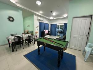 a living room with a pool table and a dining room at Baanpeanutsvilla Huahin in Hua Hin