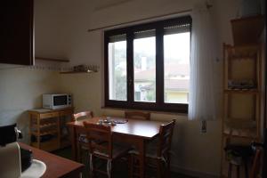a kitchen with a table and a large window at Casa Luisa in Sarroch