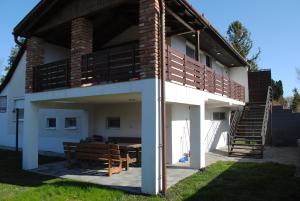 a house with a wooden table and a bench at DIÓ Vendégház in Balatonfenyves