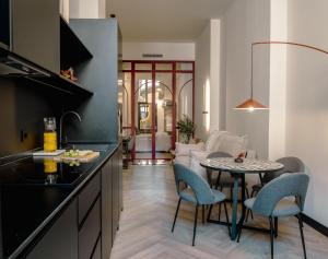a kitchen and living room with a table and chairs at Castelar Urban Suites in Badajoz