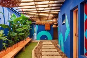 a hallway with blue walls and plants and benches at Ô de Casa Hostel Bar in São Paulo
