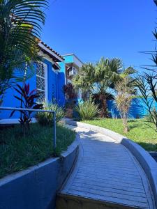 a walkway in front of a blue house at Loft Sousas in Campinas