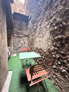 a table and two chairs sitting next to a wall at Le Duc 1 - Appartement 2 pers - Centre Ville in Valence