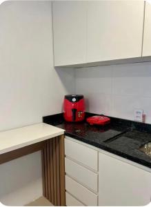a kitchen with a red appliance on a counter at Suíte completa com cozinha próximo ao mar in Torres