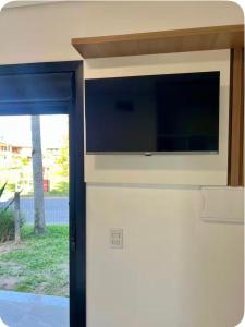 a kitchen with a microwave on top of a wall at Suíte completa com cozinha próximo ao mar in Torres