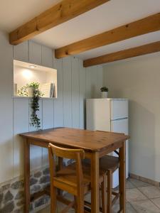 a kitchen with a wooden table and a refrigerator at La Maison dans les Nuages in Sécheras