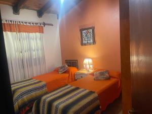 a room with two beds and a window at Casa de Piedra in El Rodeo