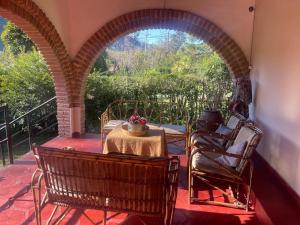 a patio with a table and chairs and an archway at Casa de Piedra in El Rodeo