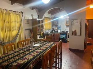 a dining room with a table and chairs and a kitchen at Casa de Piedra in El Rodeo